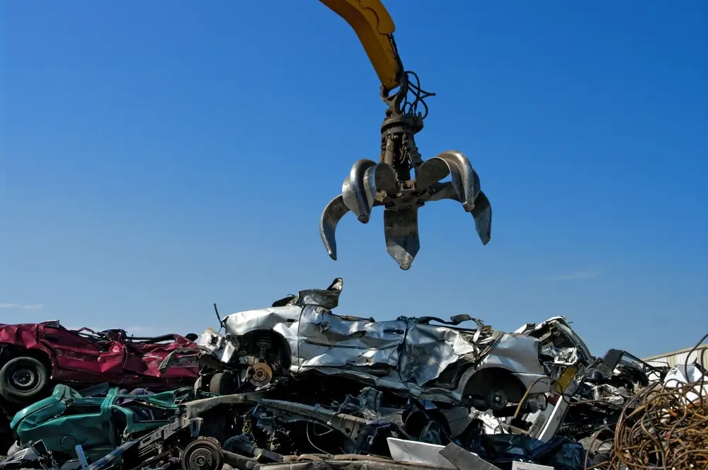 Crane picking up crushed cars