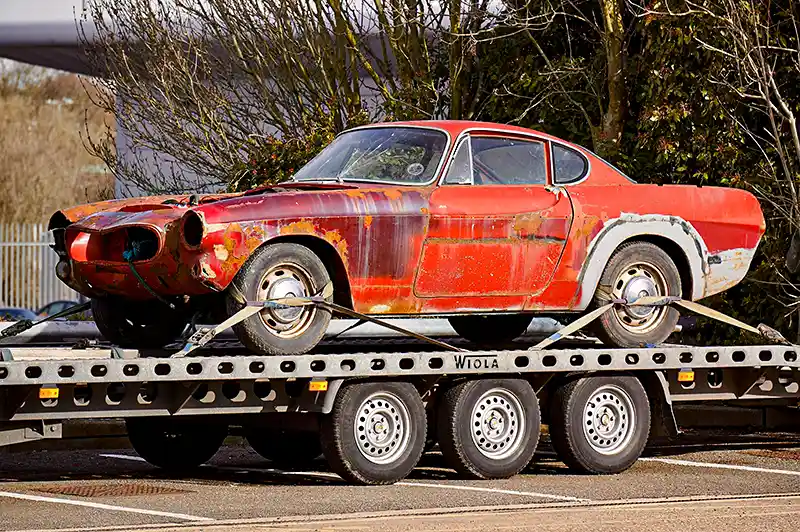 Red Coupe on Flatbed Trailer, when is it time to junk your car
